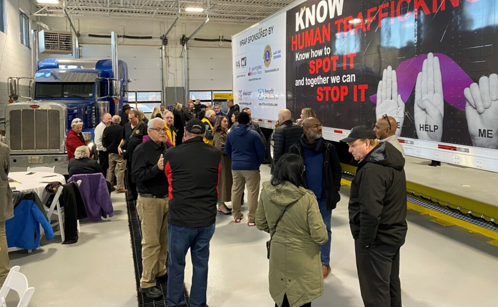 Crowd milling about in front of trailer